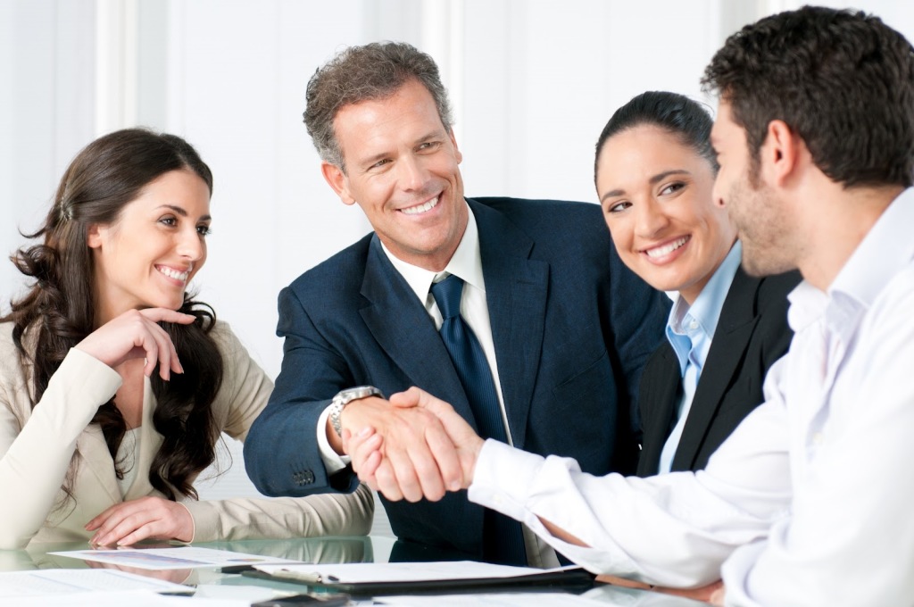 Steps to Hiring a New Employee - team smiling-with handshake